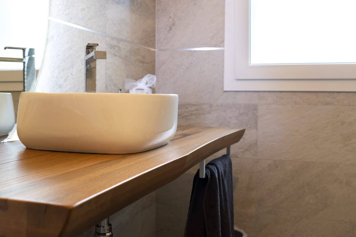 Lavabo bianco su piano in legno nel bagno